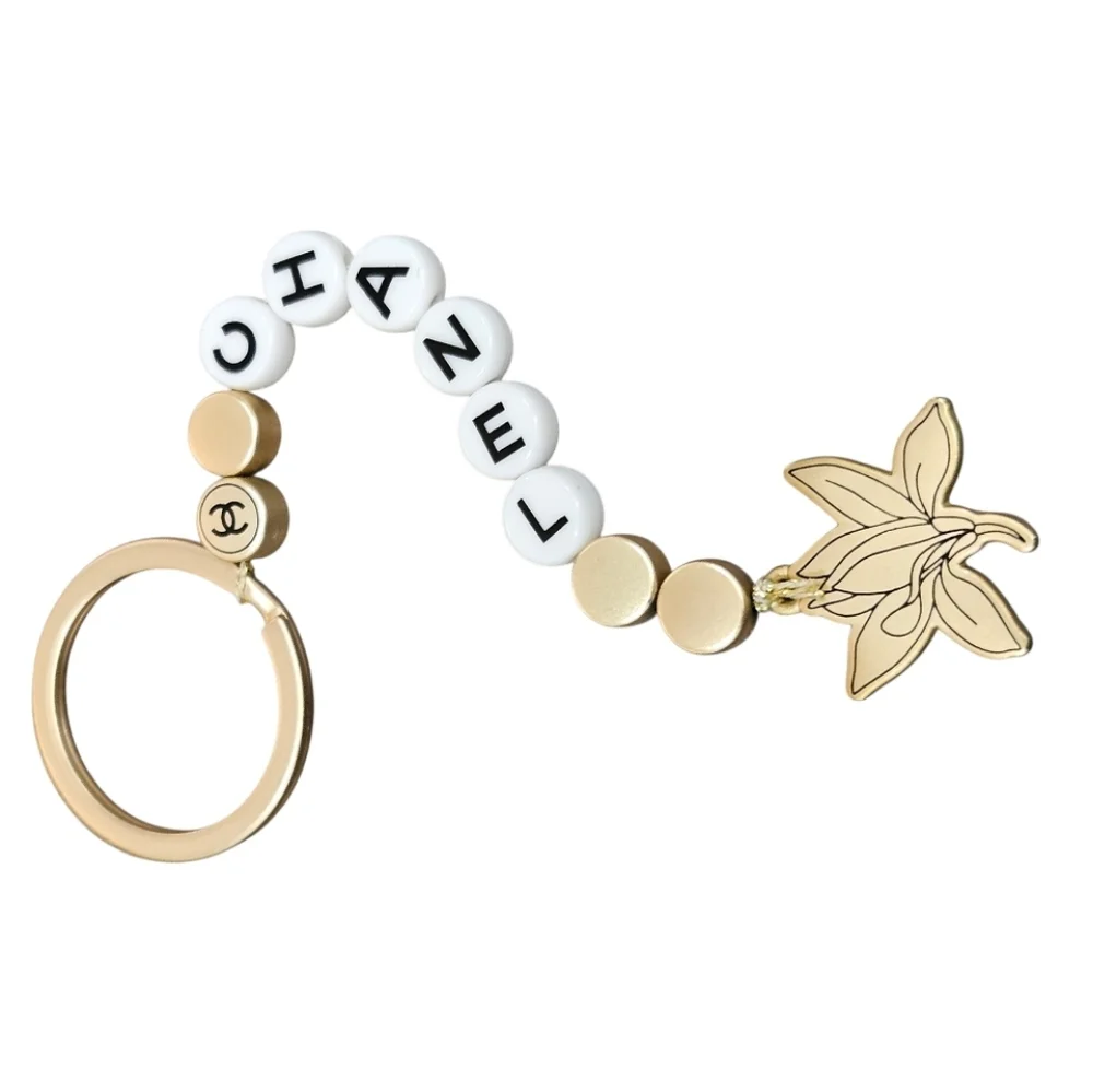 NIB CHANEL Sublimage Gold & White Beaded Keychain with Flower Charm
